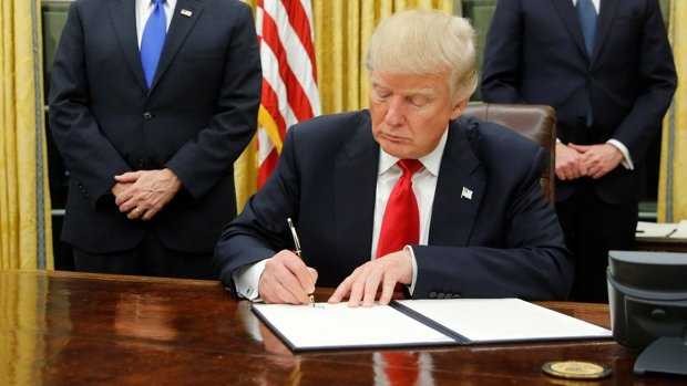 Trump, flanked by kushner, pence and porter, welcomes reporters into the oval office for him to sign his first executive orders at the white house in washington