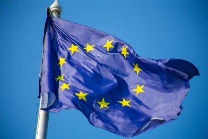 European union flag fluttering against blue sky 2048x1365 1 696x464